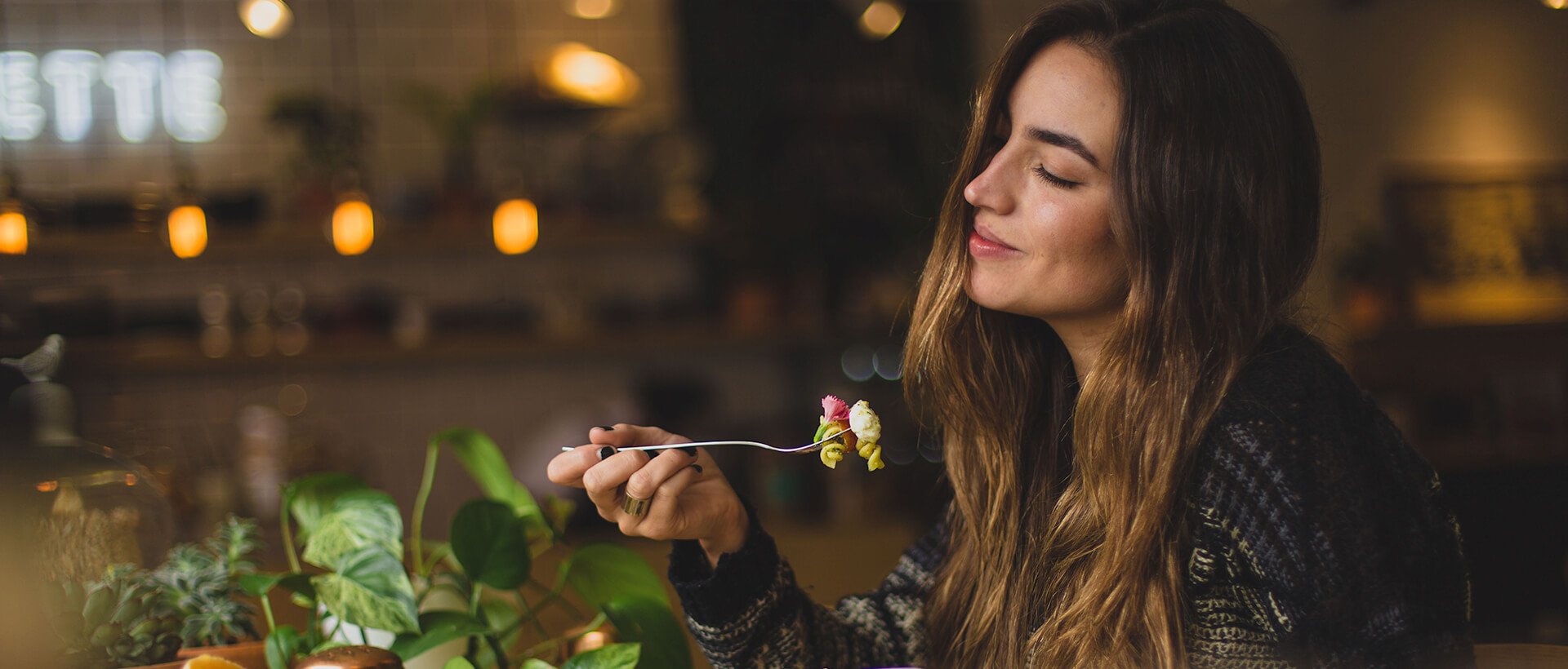 a woman holding a spoon with a flower in it.