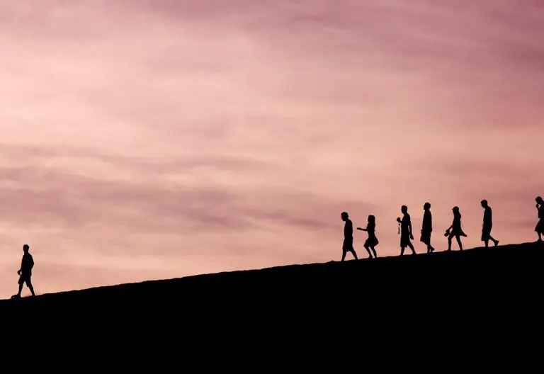 a group of people walking up the side of a hill.
