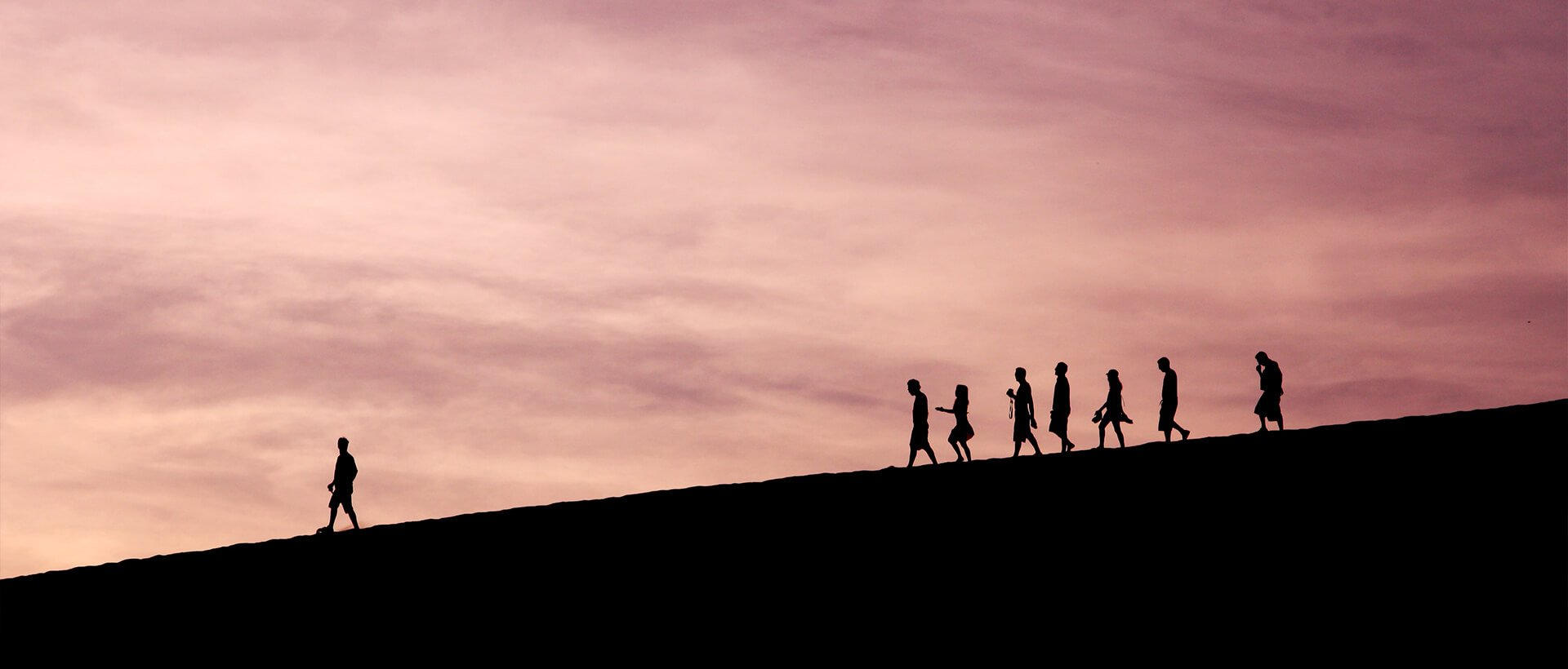 a group of people walking up the side of a hill.