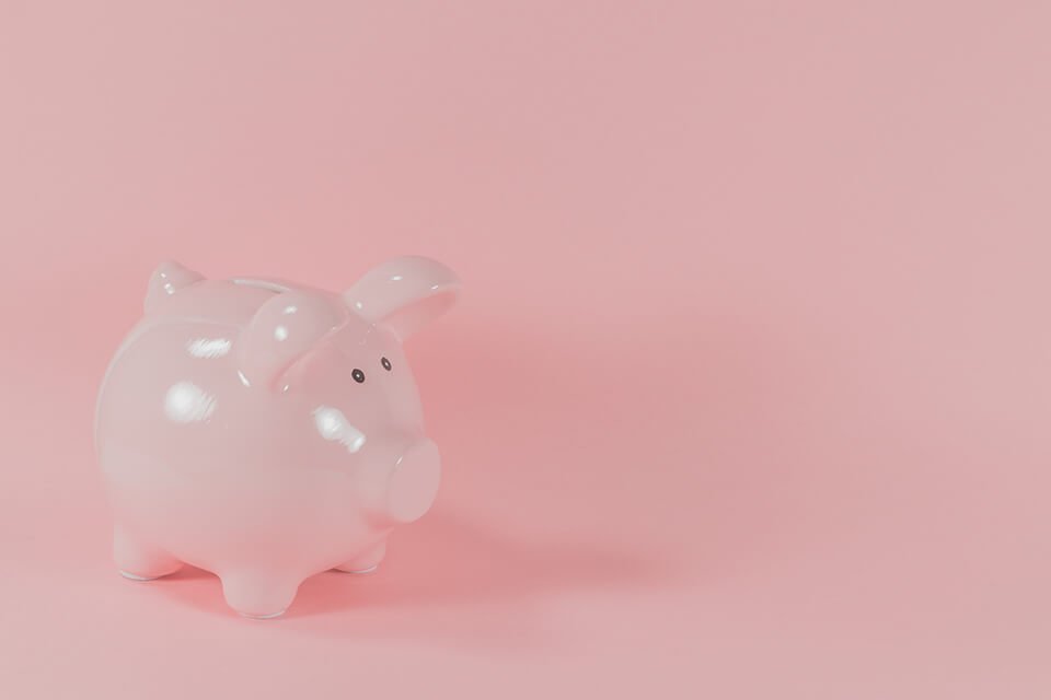Piggy bank against pink background.