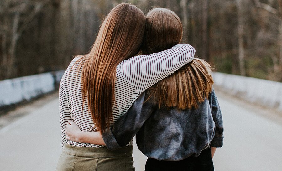 Two women hugging out in the street