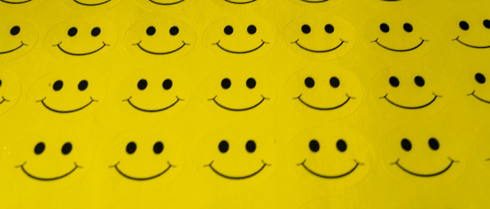 a group of smiley faces on a yellow background.