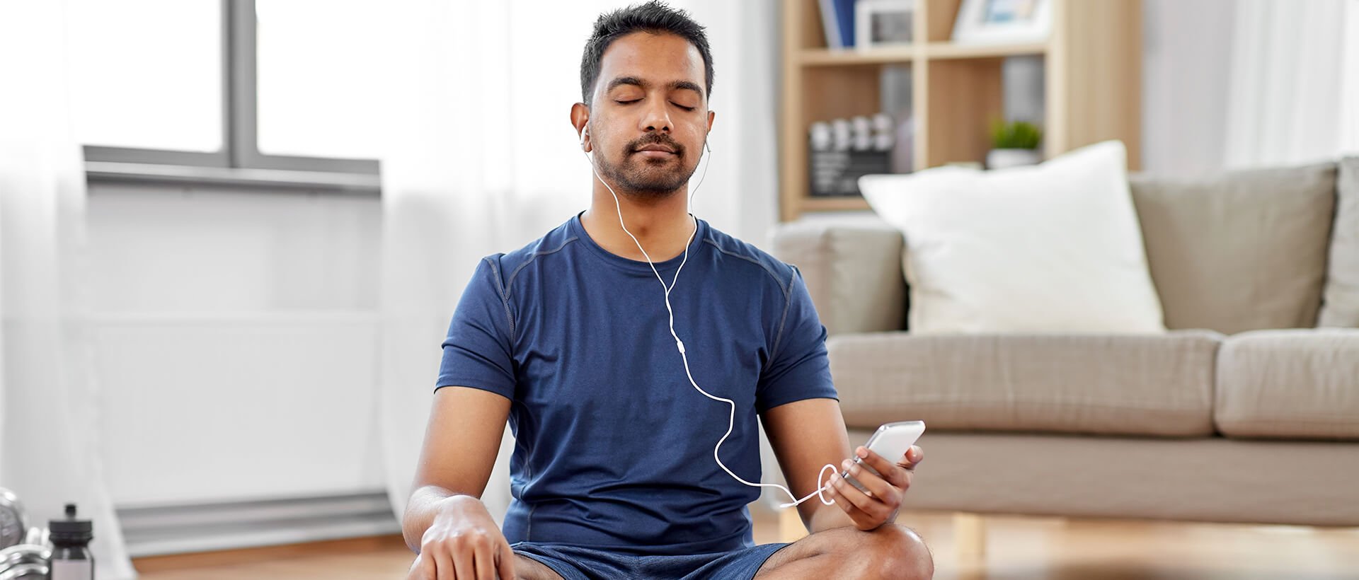 a man sitting on the floor listening to music.