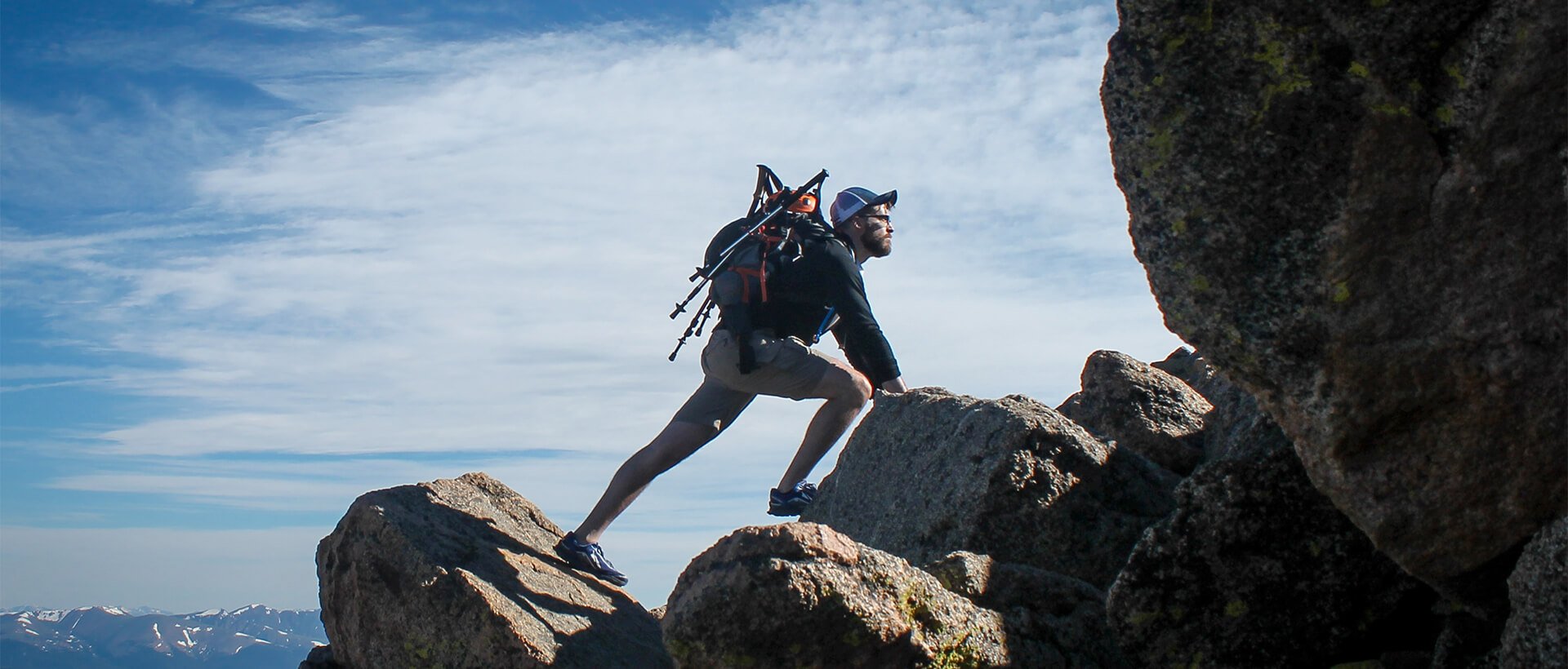 a man with a backpack climbing up a mountain.