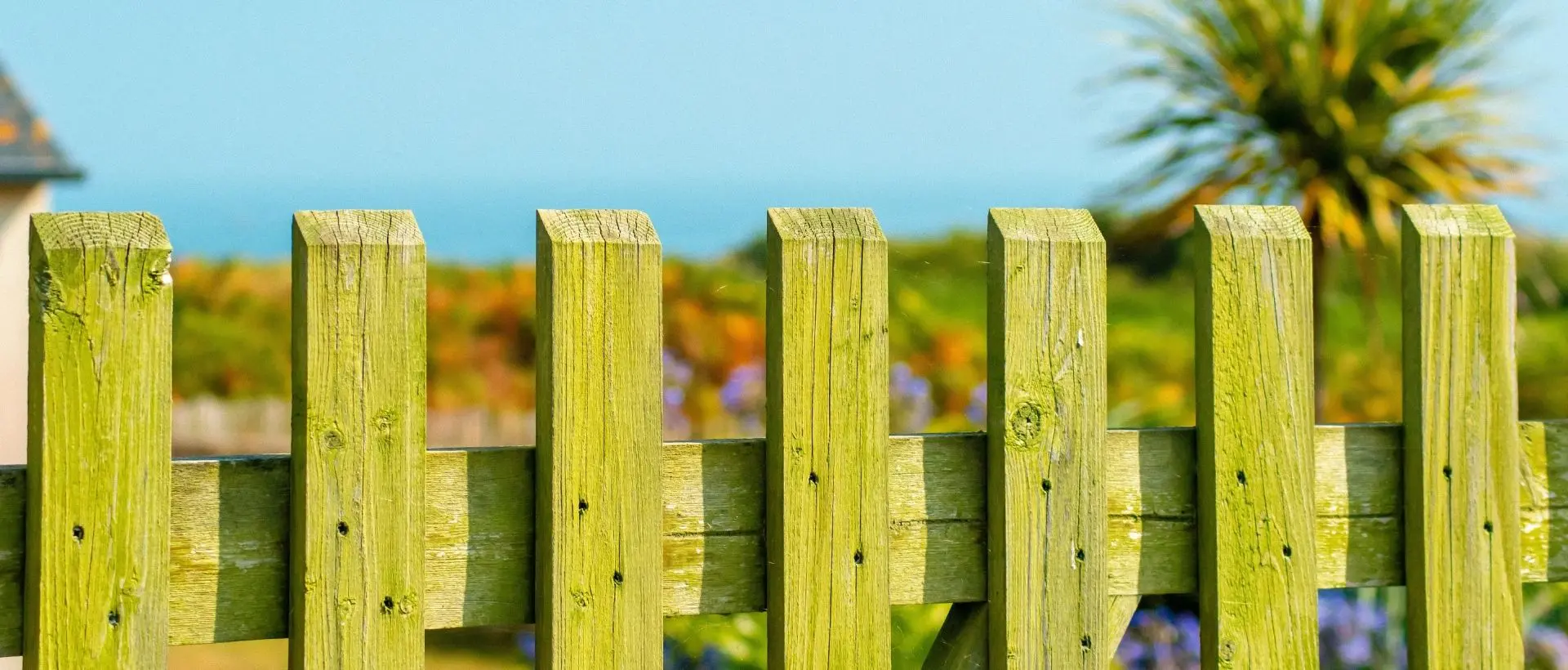 a wooden fence with a house in the background.