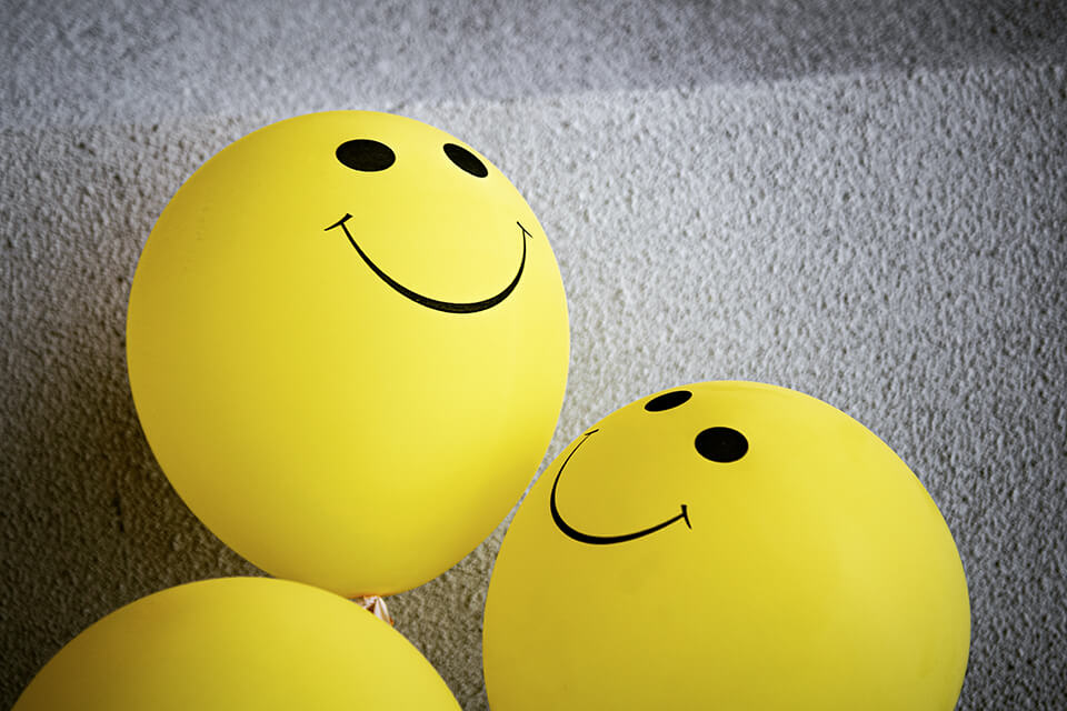 Yellow balloons with smiley faces on them
