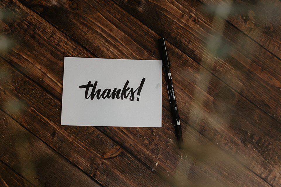 Postcard with the word "thanks!" written on with sharpie