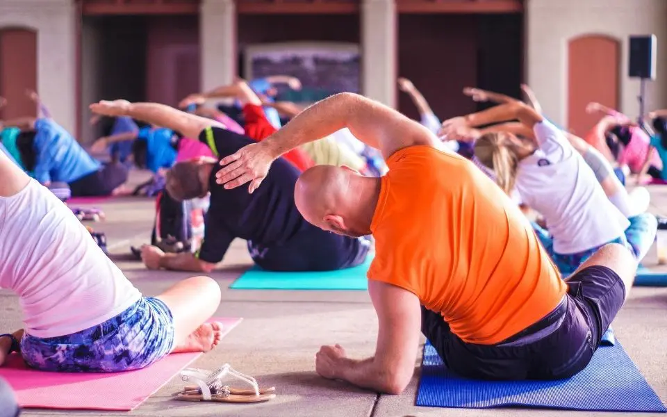 a group of people doing yoga in a gym.