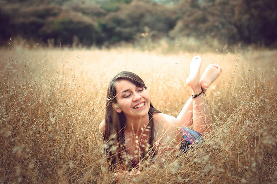 Woman laying in field smiling