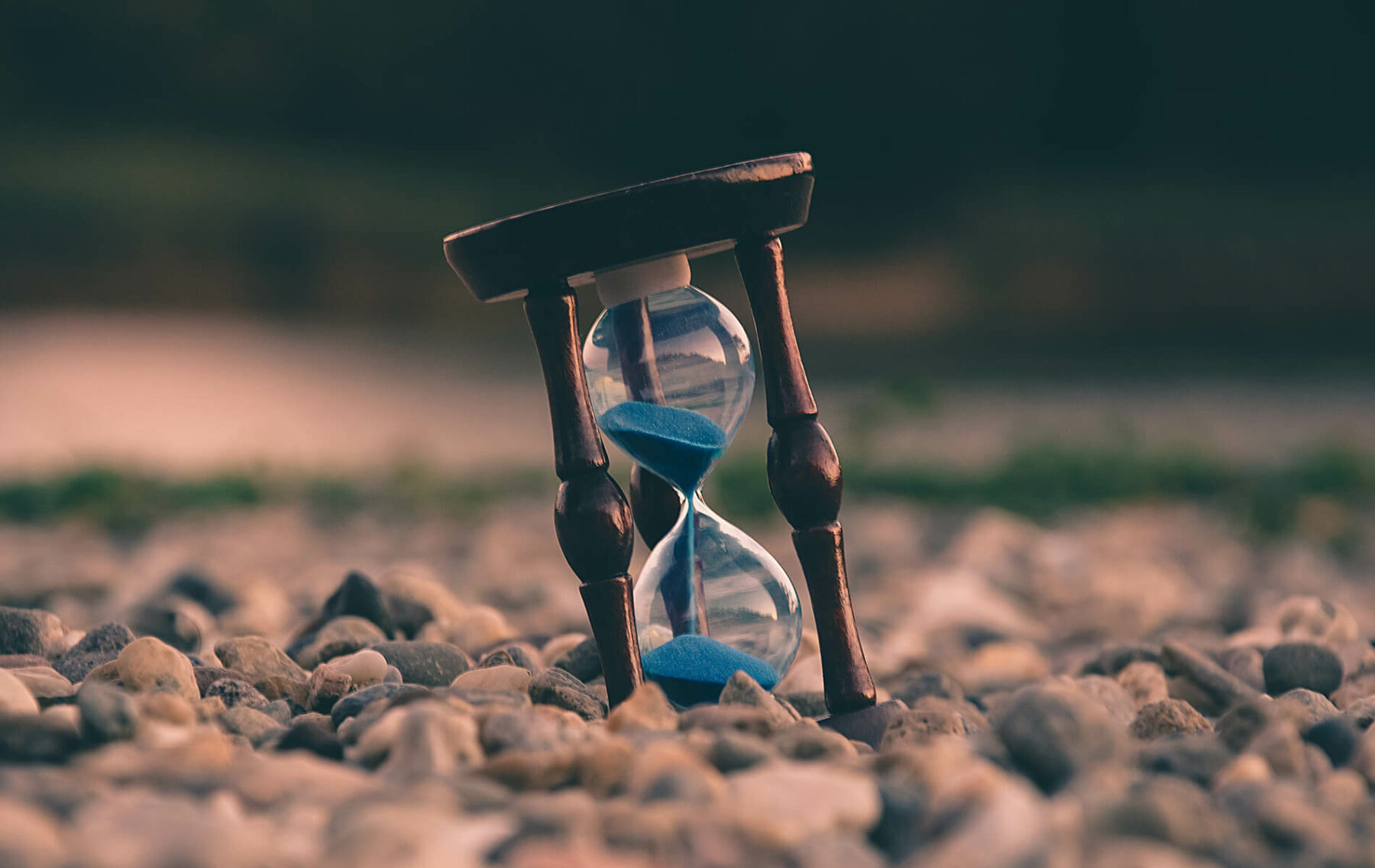 an hourglass sitting on top of a pile of rocks.