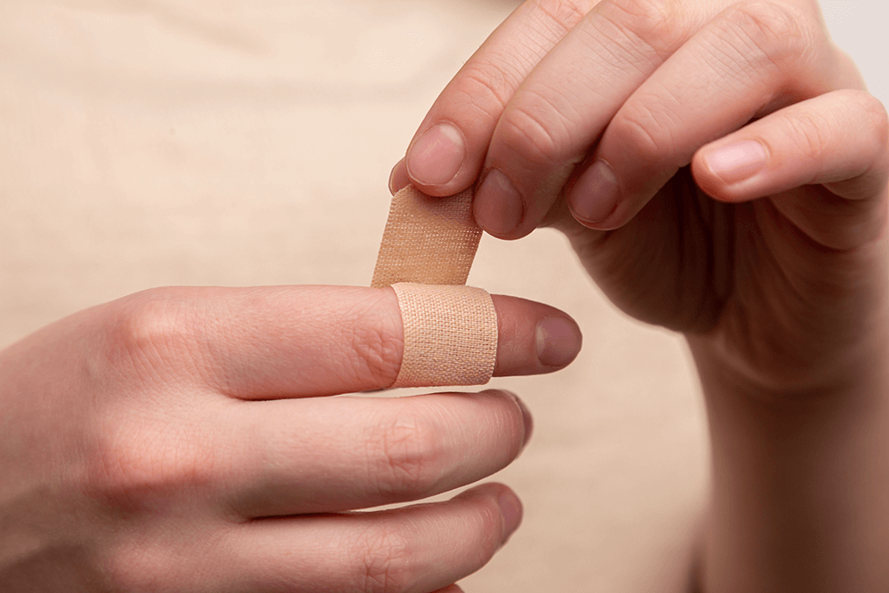 woman putting a bandaid on her finger