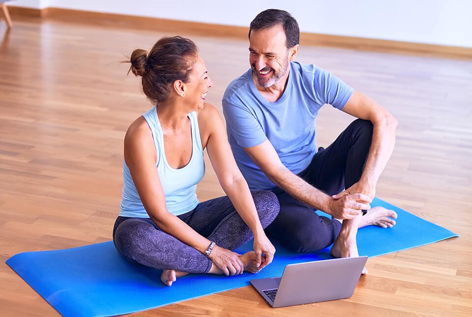 Couple looking at one another on a yoga mat in a studio